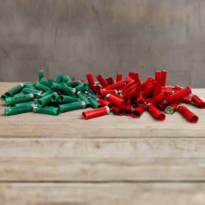 2 piles of empty shotgun shells, one green and one red, side by side on a wood plank surface