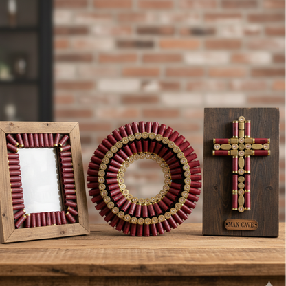 Handmade wall art frame, a circular wreath, and a cross made from empty shotgun casings displayed on a wooden table.