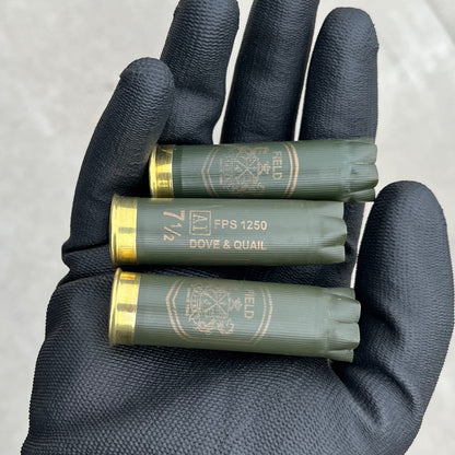 3 empty herters 12 gauge green hulls in black gloved hand showing brass headstamps