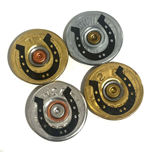 Four mixed gold and silver 12 gauge shotgun shell slices with black engraved horseshoe designs on a white background