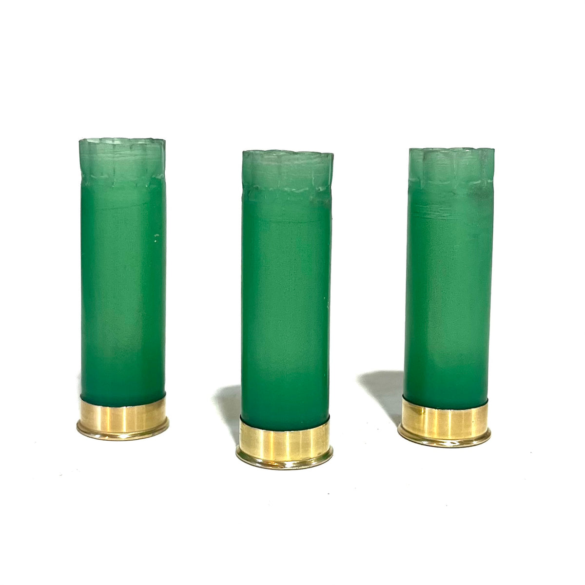 3 light green 12 gauge shotgun shell hulls with gold bases, standing upright with crimped star-fold tops on a white background