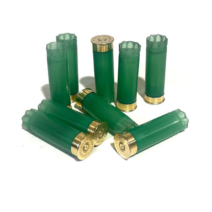 8 light green 12 gauge shotgun shell hulls with gold bases, standing and lying on a white background