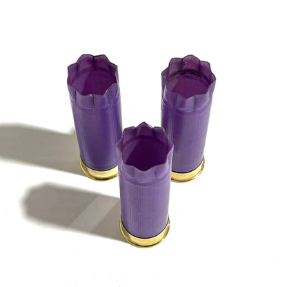 Three light purple casings standing upright in a triangle arrangement, all showing open 8 star crimped tops