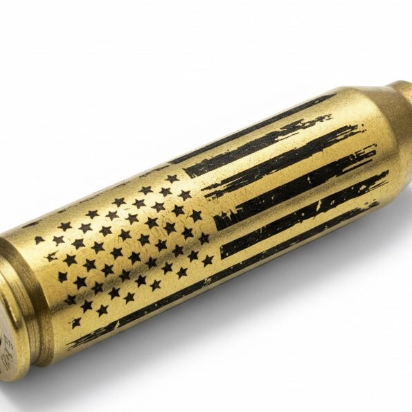 Macro shot of distressed American flag engraving on an authentic once-fired 308 Win brass dummy round casing.
