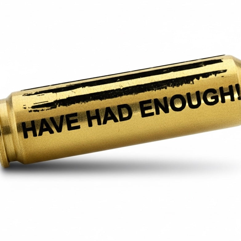 Macro close-up of HAVE HAD ENOUGH and distressed American flag engraving on a horizontal 308 Winchester brass casing.
