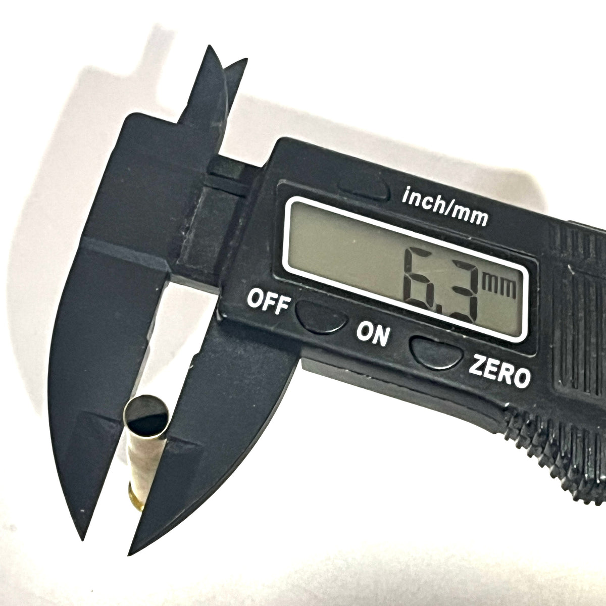 Digital caliper measuring a drilled .22 Hornet brass casing at 6.3 mm