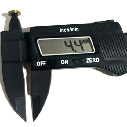 Digital caliper measuring the diameter of a deprimed brass bullet slice showing 4.4 mm