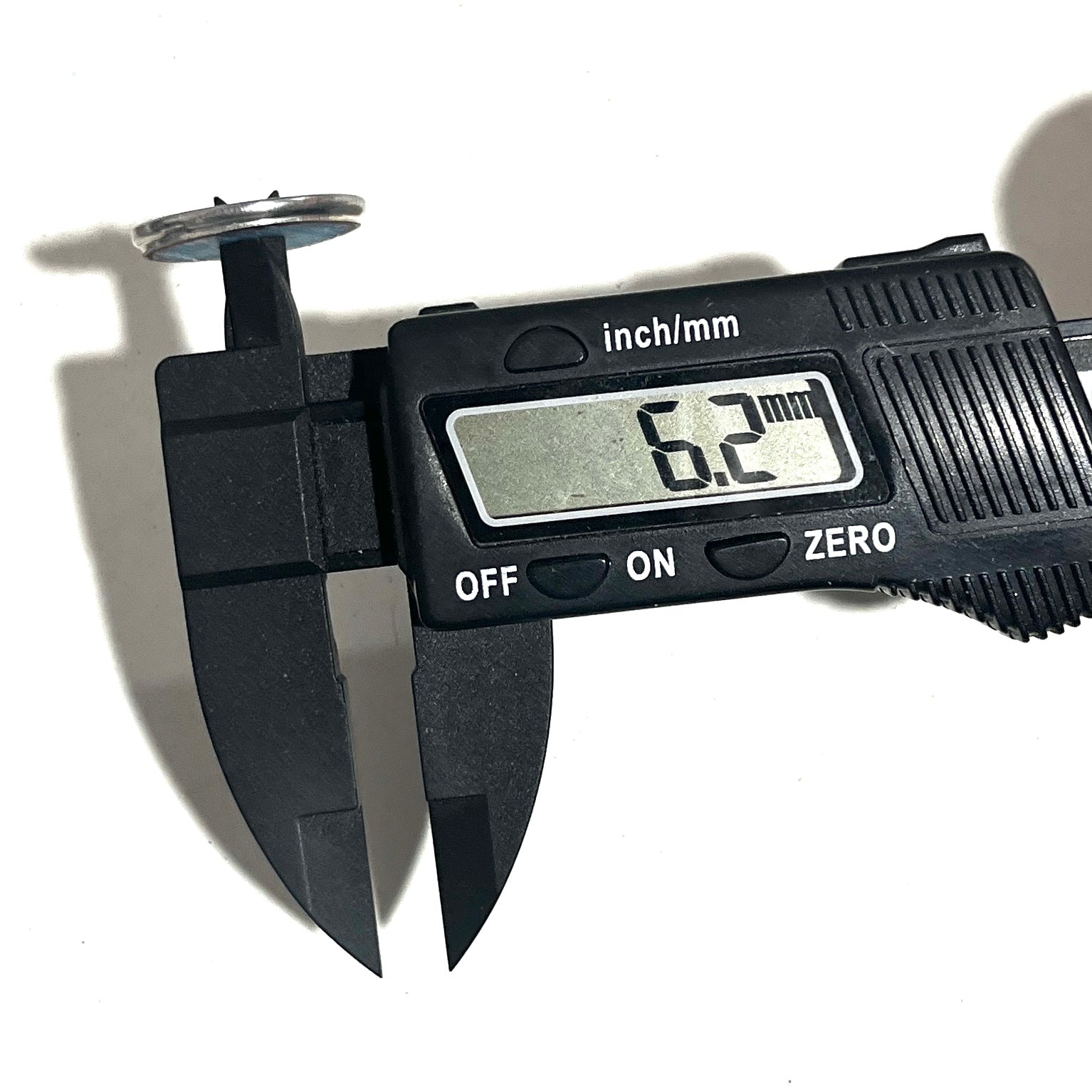 A digital caliper measuring the inside diameter of a silver shotgun shell slice on a white background.