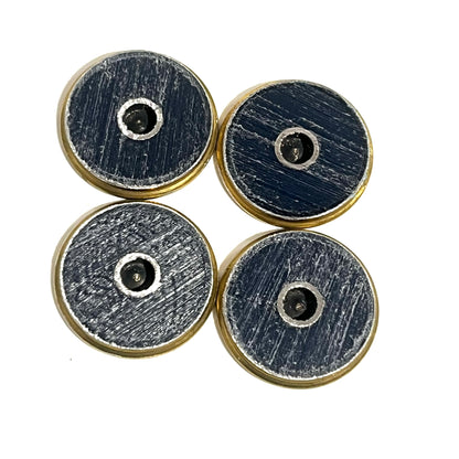 4 shotgun shell slices viewed from the reverse side showing dark blue scratched hulls with drilled holes and brass rims