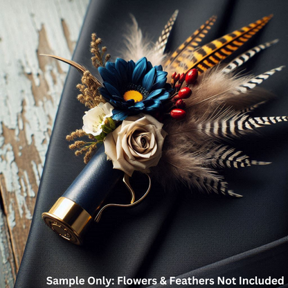 Navy blue shotgun shell boutonniere arrangement with blue flower and feathers resting on dark fabric.