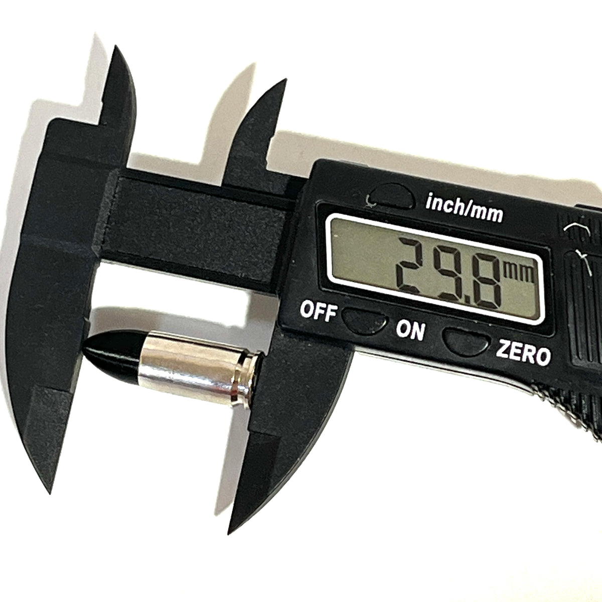 Digital caliper measuring a nickel 9mm Luger dummy round's overall length at 29.8 millimeters