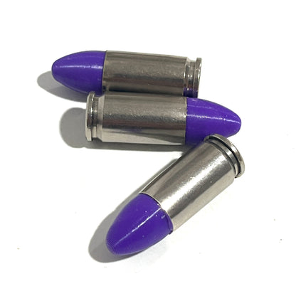 3 nickel 9mm Luger cartridges with purple bullet tips lying at angles on a white background