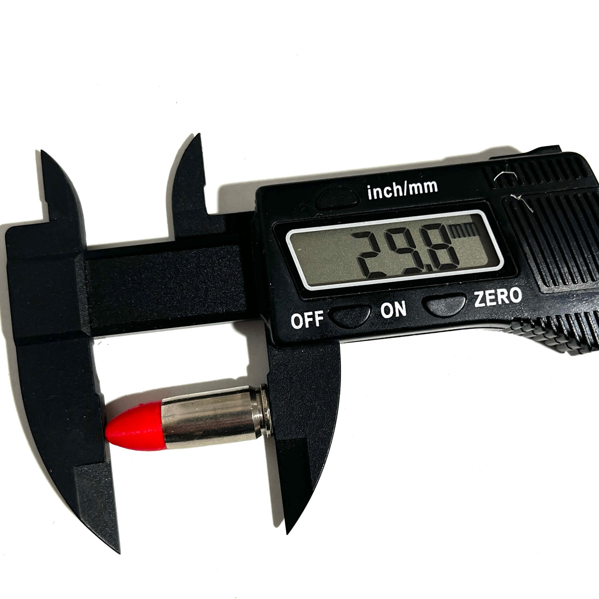 Digital caliper measuring the length of a fake nickel 9mm Luger dummy round with red tip at 29.8mm