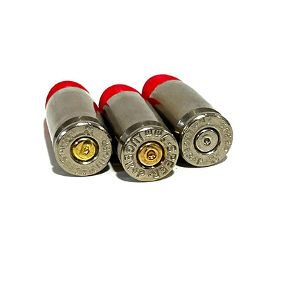 3 fake nickel 9mm Luger dummy round bases viewed from behind showing mixed headstamp markings