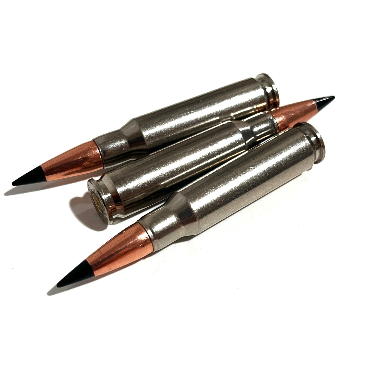 Three nickel .308 cartridges fanned together with black tips on a white background, primer visible
