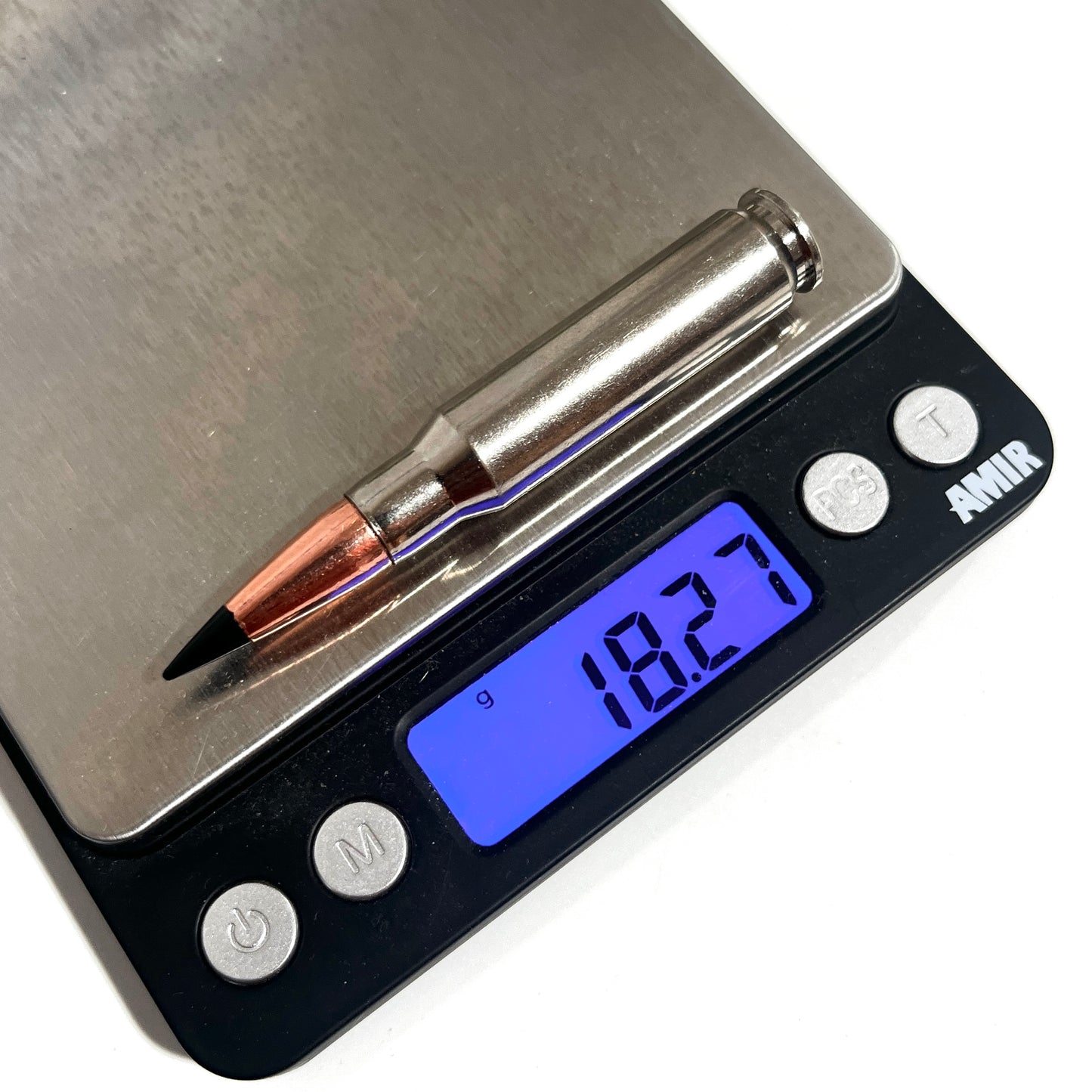 Nickel .308 dummy cartridge on a digital scale displaying a weight of 18.27 grams