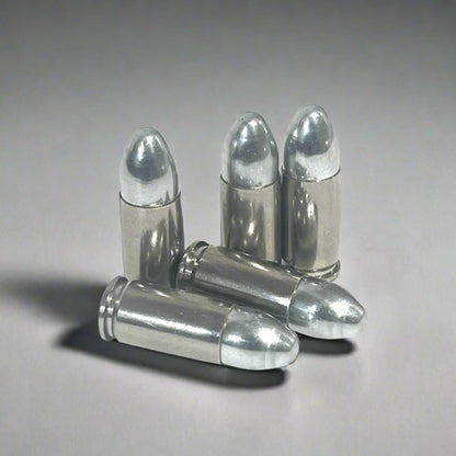 Five nickel 9mm hulls, three standing upright and two crossed in front, on a gray background.