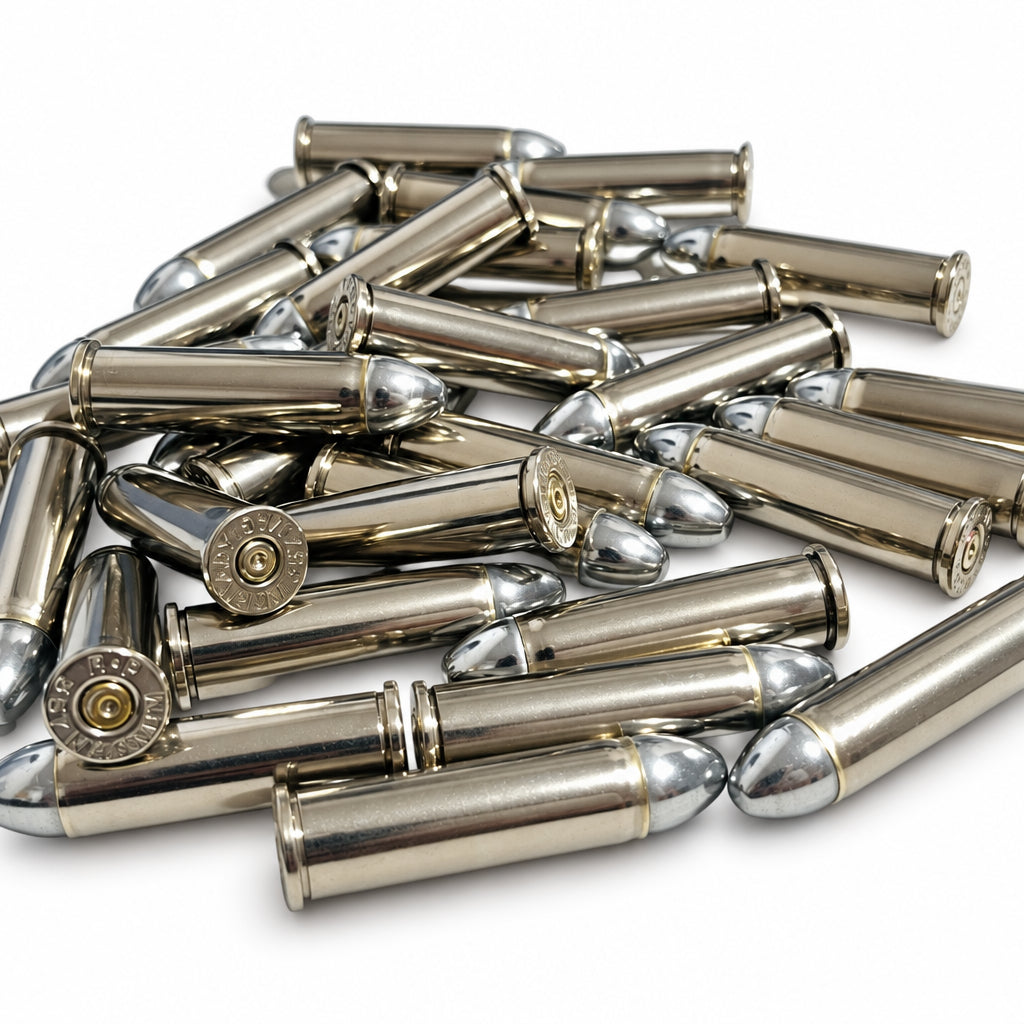 Loose pile of spent nickel 357 Magnum cartridges with seated round nose bullets on a white background