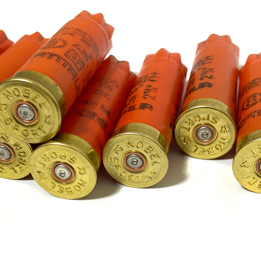 Close-up of orange Nobel Sport 12 gauge shotgun shells showing brass headstamps
