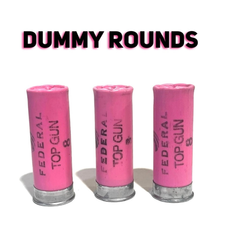 Three pink Federal Top Gun 8 dummy shotgun shell hulls standing upright labeled DUMMY ROUNDS