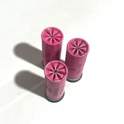 Three pink Federal shotgun shells with fluted star crimp tops on a white background