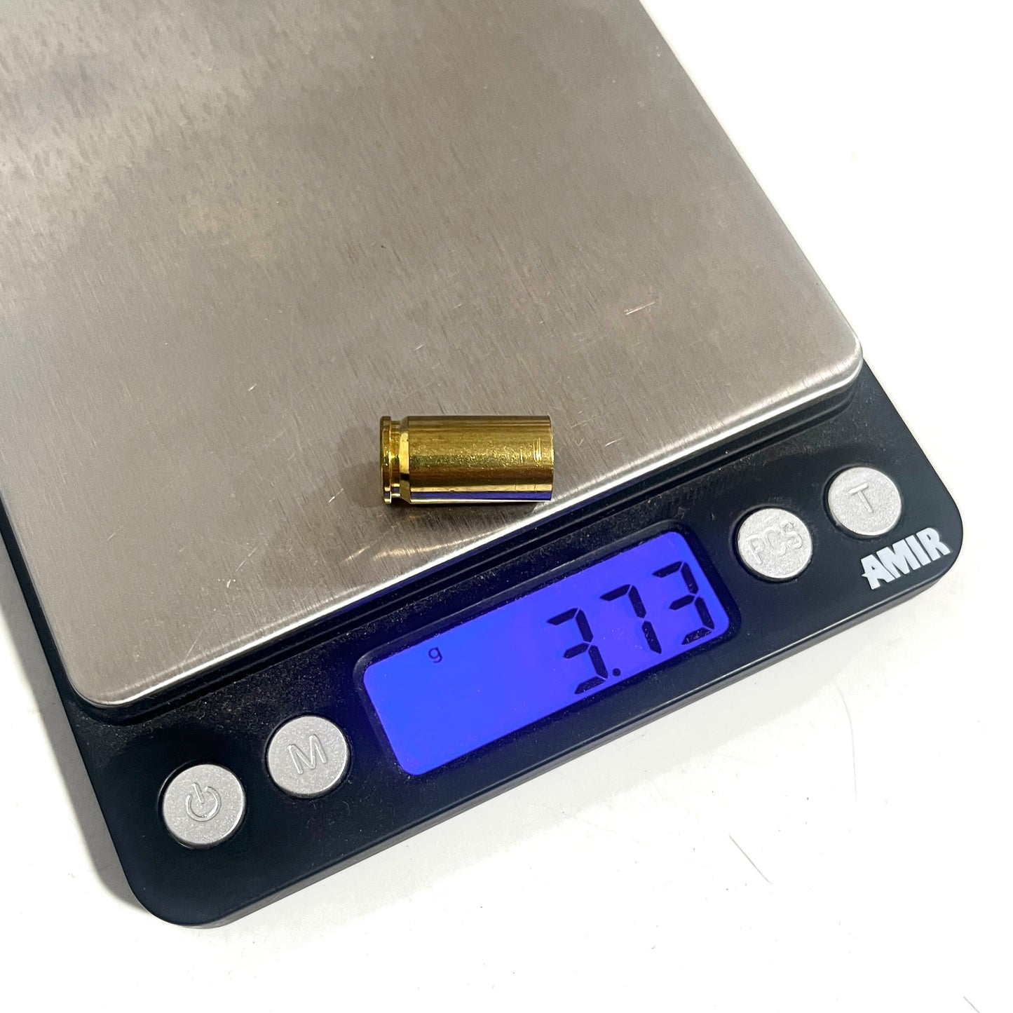 Single cleaned and polished 9mm empty brass shell casing on a digital scale showing a weight of 3.73 grams.