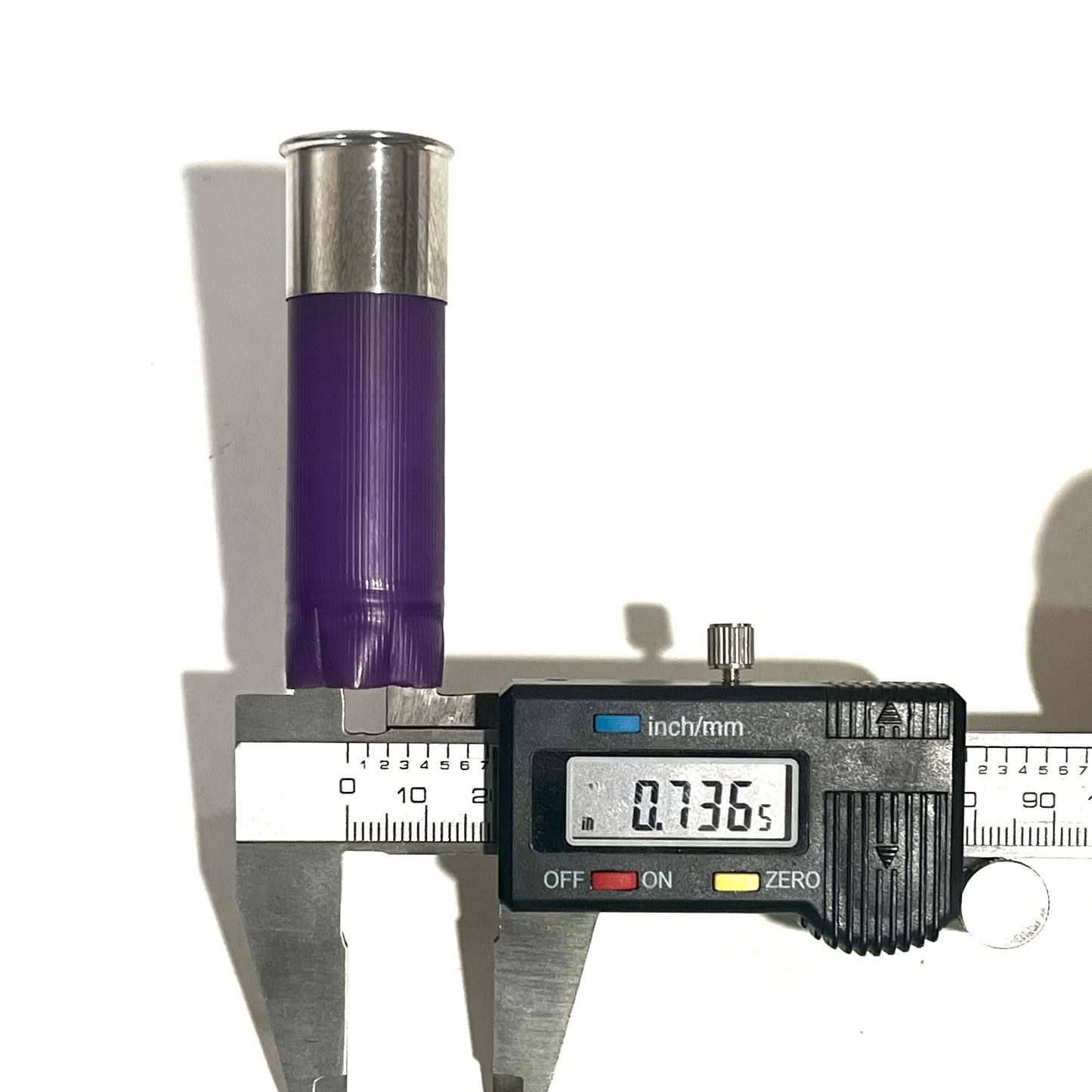 Digital caliper measuring a purple 12 gauge shotgun shell hull's diameter at 0.736 inches
