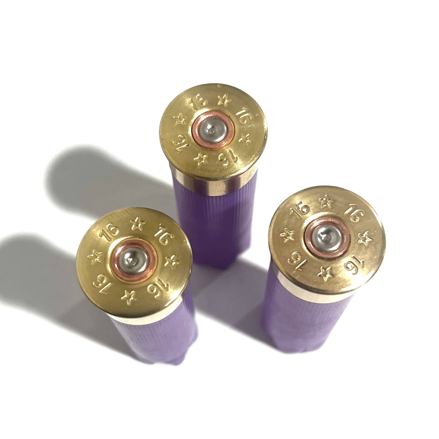 3 purple 16 gauge shotgun shell hulls viewed from above showing brass headstamps marked 16
