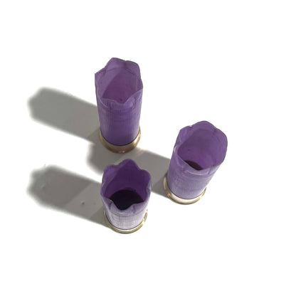 3 purple 16 gauge shotgun shell hulls with open crimped and cut ends, viewed from above