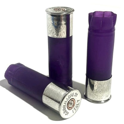 3 purple 12 gauge shotgun shell hulls with silver Bornaghi base caps, standing and lying on a white background