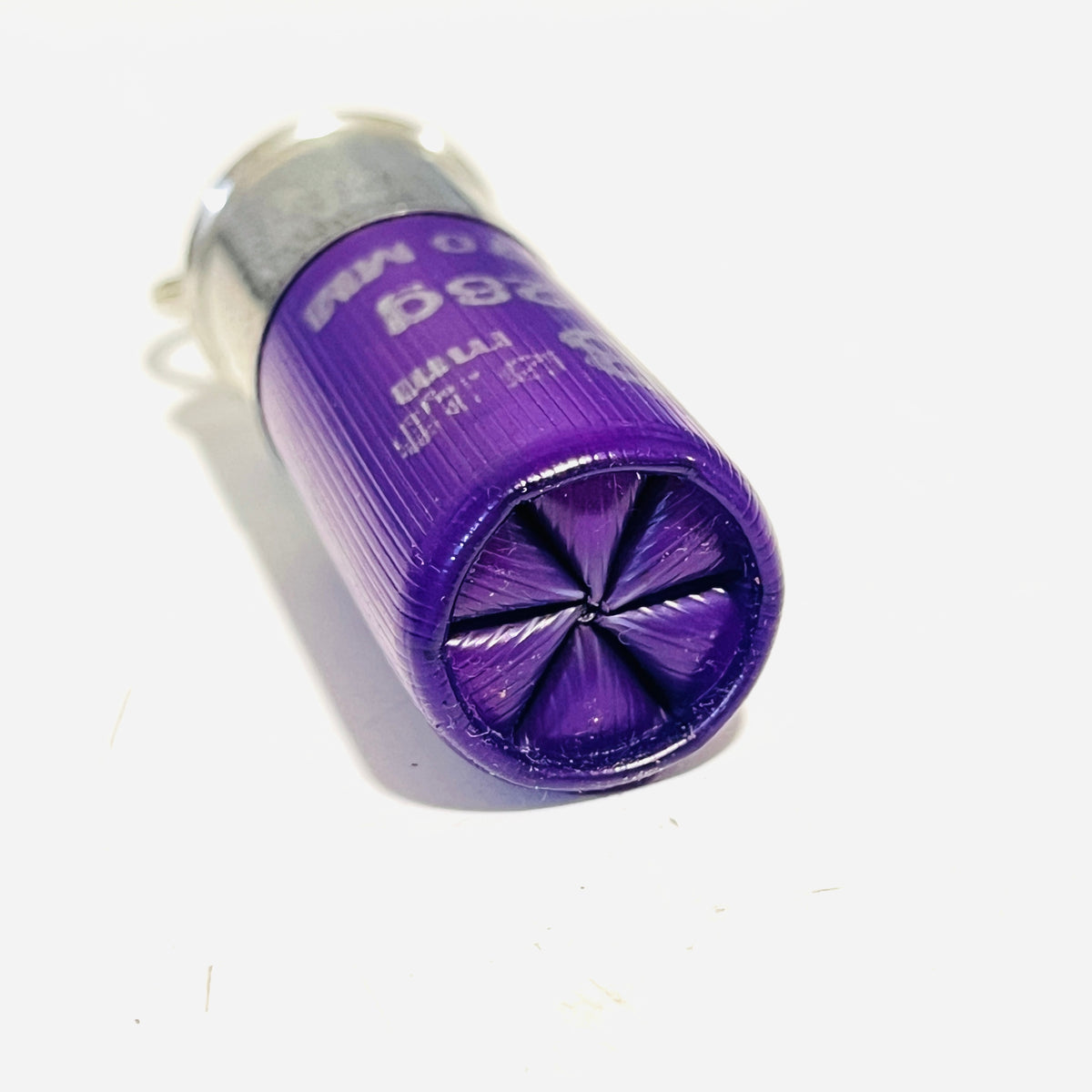 Close-up of the folded 6-point star crimp on an empty purple shotshell keychain