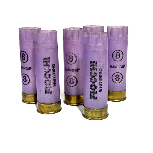 5 purple Fiocchi Whiterino 12 gauge shotgun shells with 8 shot size printed on the hulls, standing upright with brass bases