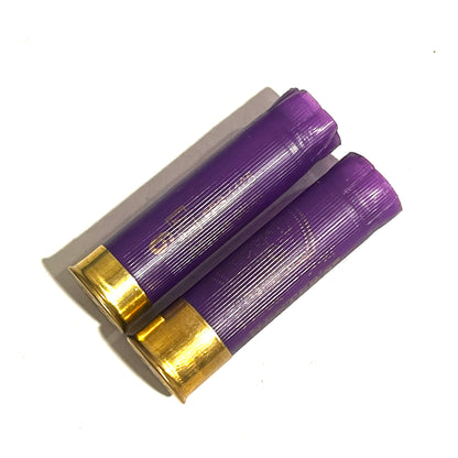 Two purple 16 gauge shotgun shells with brass bases lying side by side on a white background