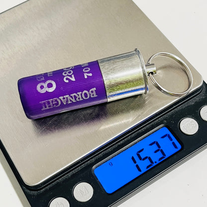 Once-fired purple Bornaghi shell keychain on a digital scale reading 15.37 g, with the steel split ring attached