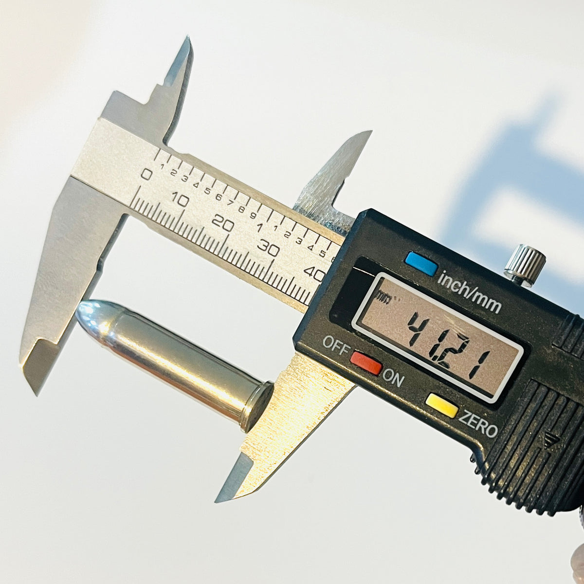 Digital caliper measuring the length of a nickel 357 Magnum realistic dummy round at 41.21 millimeters