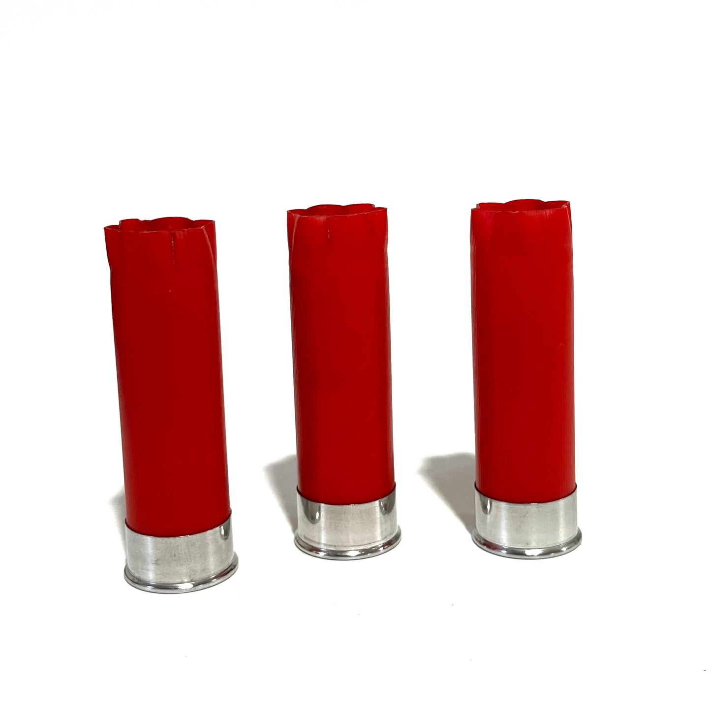 Three red shotgun shells with silver bottoms standing upright on a white background