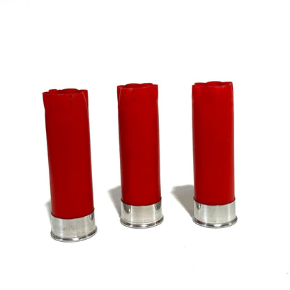 Three red shotgun shells with silver bottoms standing upright on a white background