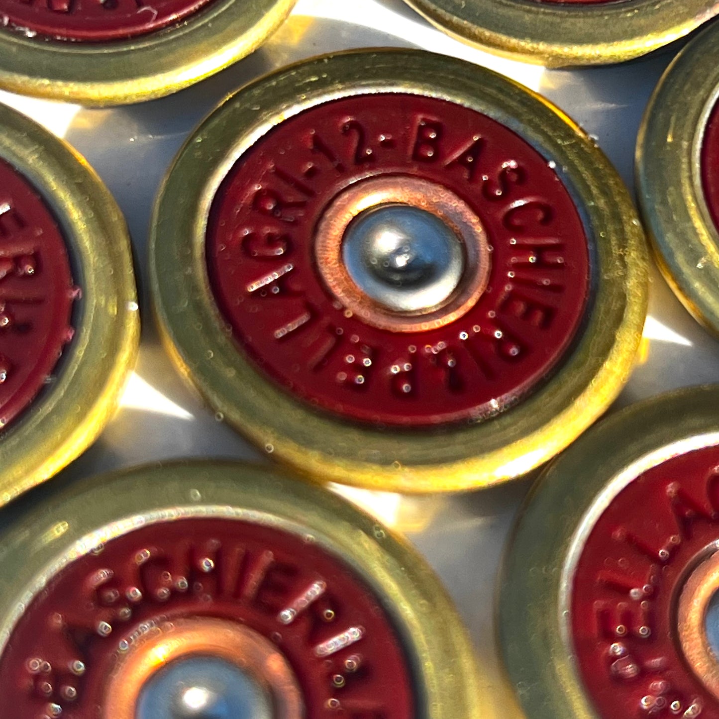 7 Baschieri and Pellagri 12 GA red shotgun shell slices with brass rims viewed close-up