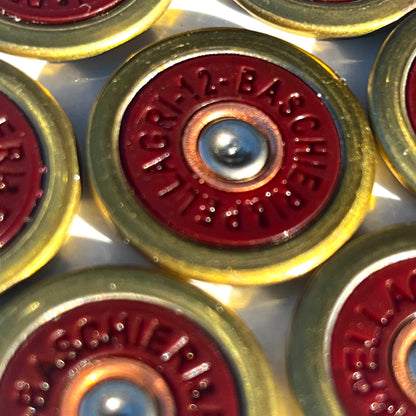 7 Baschieri and Pellagri 12 GA red shotgun shell slices with brass rims viewed close-up