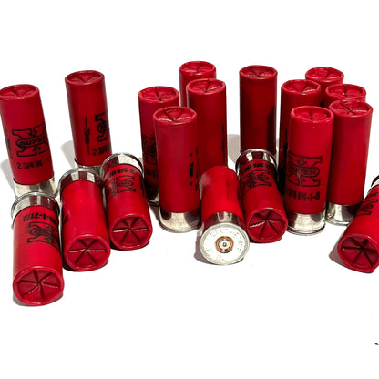 Pile of red empty hulls scattered at different angles showing star-crimped tops and worn bases