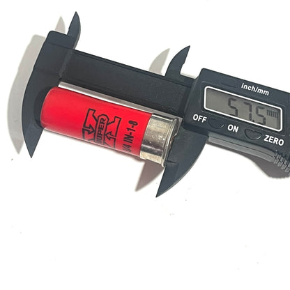 A red once-fired shell measured for diameter with a black digital caliper reading 57.5 mm.