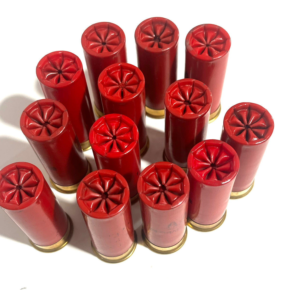 12 red Winchester AA International 12 gauge shotgun dummy rounds standing upright in cluster with star crimp tops
