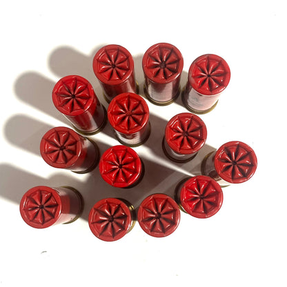 12 red Winchester AA International 12 gauge shotgun dummy rounds viewed from above showing star crimp tops in cluster