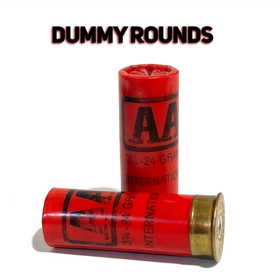 Two red Winchester AA International 12 gauge shotgun dummy rounds, one standing and one on its side, Dummy Rounds text overlay