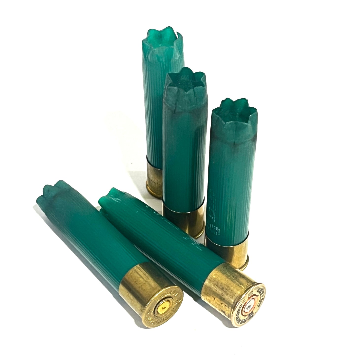 Five green 28 gauge empty shotgun hulls standing and lying on a white background.