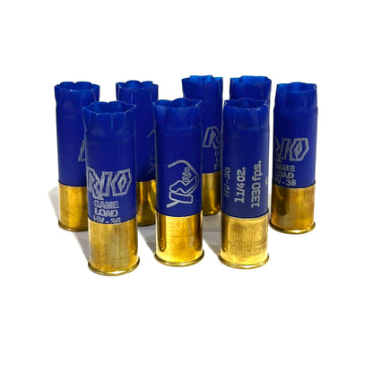 9 empty blue 12 gauge RIO Game Load shotgun shells with brass bases standing on a white background