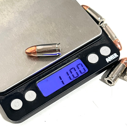 A black digital scale weighing a single nickel 9mm cartridge, showing a reading of 11.00 g.