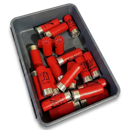 A collection of red shotgun hulls with silver brass bases filling a grey metal bin on a white background.
