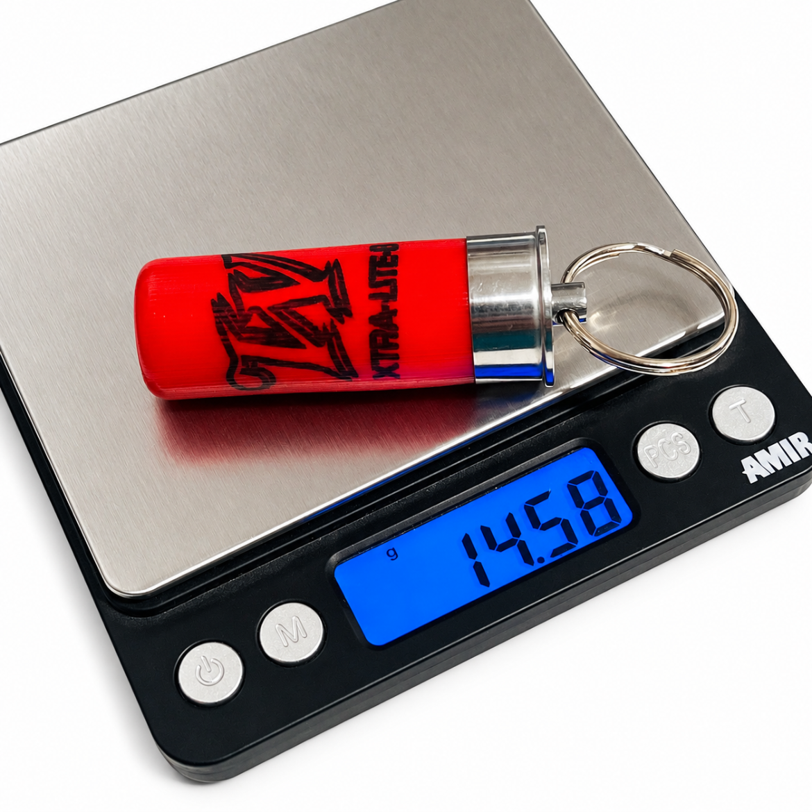 Empty red hull keychain on a digital scale weight reading 14.58 g