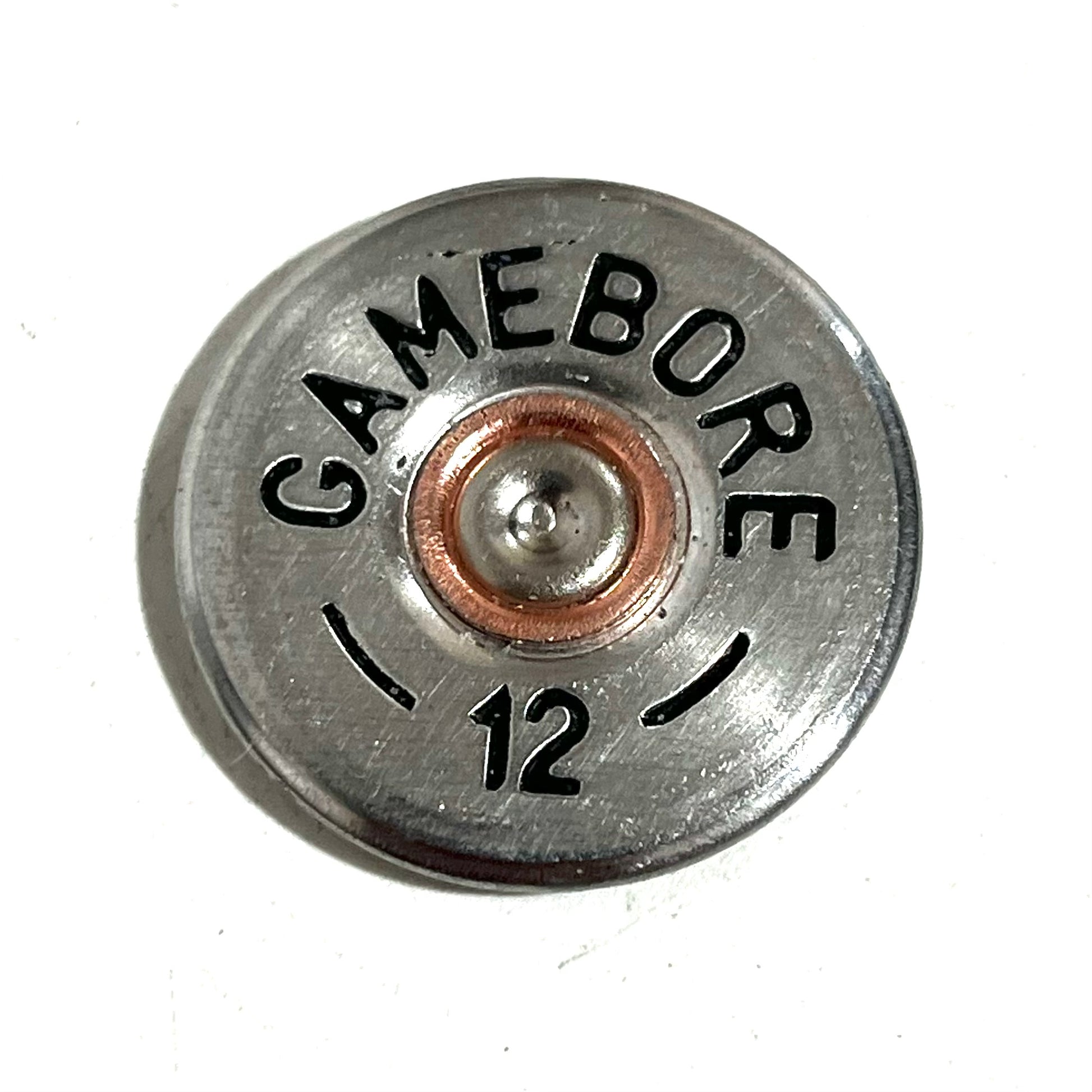 Close-up of a round silver Gamebore 12 gauge shotgun shell slice with a copper primer center